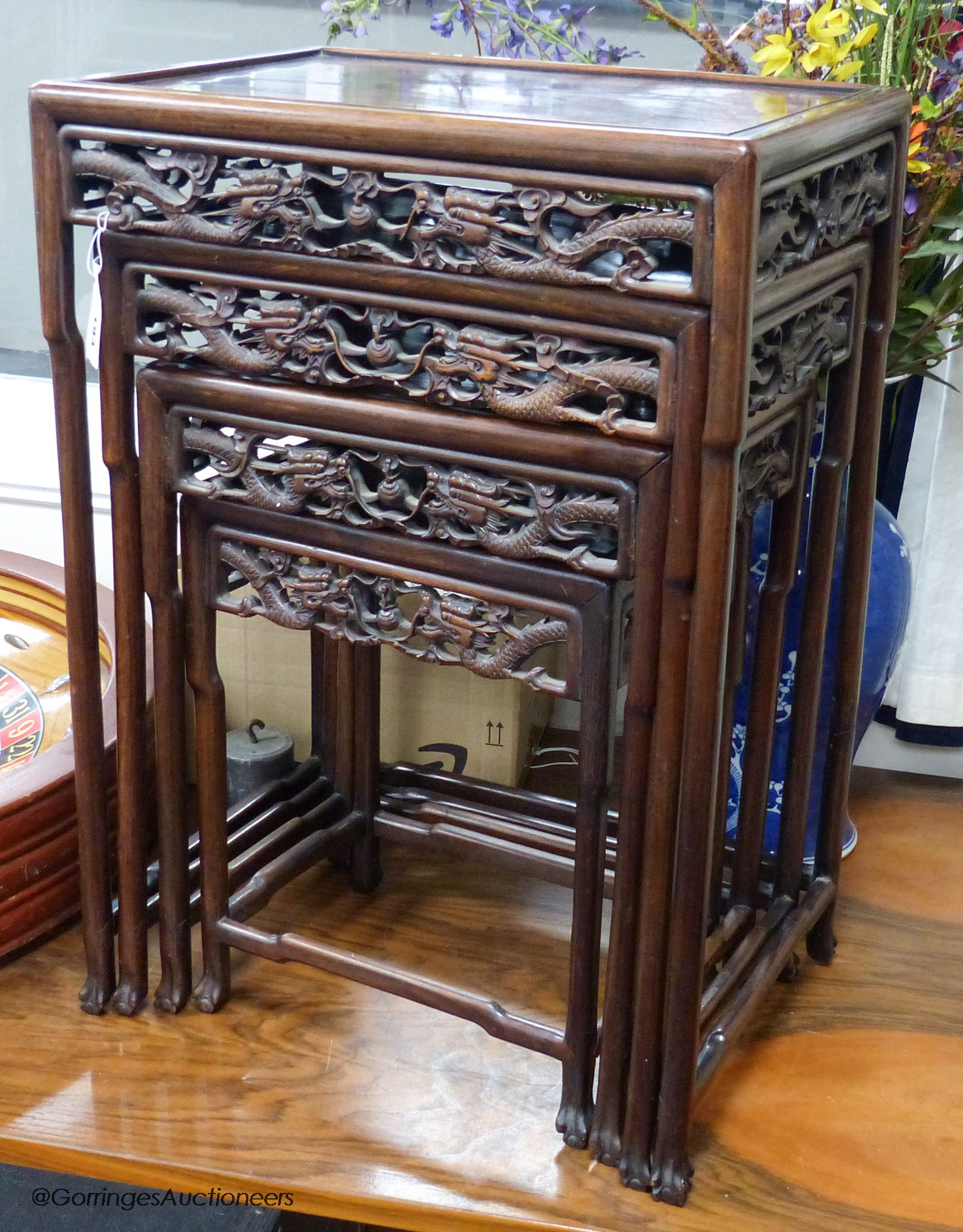 A Chinese nest of four hongmu tables, early 20th century, with a dragon carved freeze, largest table 50.5 cm high, 37 cm deep, 72 cm high